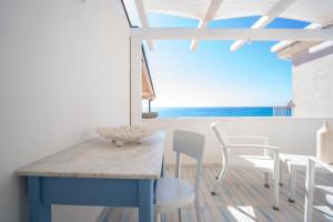 a blue table and chairs in a room with a view of the ocean at I Gradini sul Mare in Santa Maria +43 photos