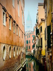 a canal in a city with buildings and a bridge at Venice Station Guest House in Mestre