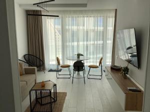 a living room with a table and chairs at Ammos Apartment Mamaia in Mamaia