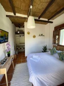 Un dormitorio con una cama blanca y una mesa. en El Paisaje, en Atajate