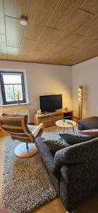 a living room with a couch and a television at Ferienwohnung Waldenburg Sachsen in Waldenburg