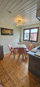a dining room with a table and pink chairs at Ferienwohnung Waldenburg Sachsen in Waldenburg
