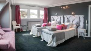 a room with two beds and a couch in it at Logis Hotel Du Casino Restaurant Le Mathelia in Vierville-sur-Mer