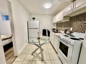 una cucina con tavolo in vetro e frigorifero bianco di Comfortable place In An Amazing Location a Toronto Altre 4 foto