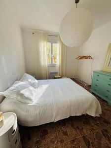 a bedroom with a large white bed and a window at Appartement au cœur de Cargèse in Cargèse