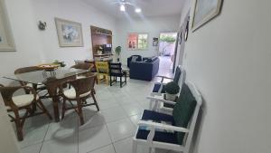 a dining room and living room with a table and chairs at casa do Pedro in Guarujá