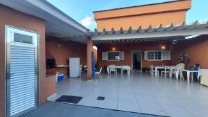 a patio with tables and chairs and a building at casa do Pedro in Guarujá