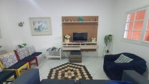 a living room with a couch and a tv at casa do Pedro in Guarujá