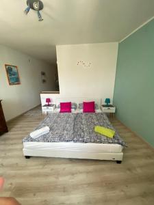 ein Schlafzimmer mit einem Bett mit zwei rosa Kissen in der Unterkunft Lakeside apartment in Orta San Giulio