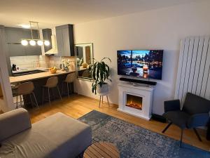 a living room with a kitchen and a living room with a fireplace at Lake Garden - Cozy Two-Bedroom Apartment with flexible Check-In, Terrace, and Netflix in Zagreb