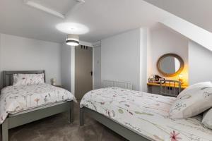 une chambre avec deux lits et un miroir dans l'établissement Rose cottage, à Dungannon