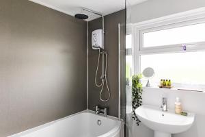 La salle de bains est pourvue d'une douche, d'un lavabo et d'une baignoire. dans l'établissement Rose cottage, à Dungannon 38 autres photos