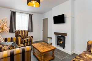 un salon avec des canapés et une cheminée dans l'établissement Rose cottage, à Dungannon