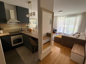 a kitchen and a living room with a couch at Lake Garden - Cozy Two-Bedroom Apartment with flexible Check-In, Terrace, and Netflix in Zagreb