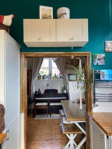 eine Küche mit Tisch und ein Zimmer mit Klavier in der Unterkunft St Catherines Cottage The Old Schoolhouse in Long Melford + 13 Fotos