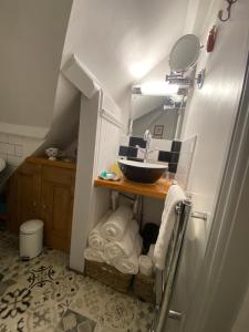 ein kleines Badezimmer mit Waschbecken und Spiegel in der Unterkunft St Catherines Cottage The Old Schoolhouse in Long Melford