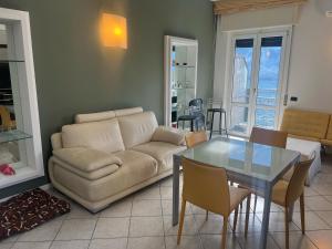 a living room with a couch and a table at Casa Onda Parcheggio gratuito in Laglio +8 photos