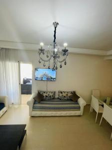 a living room with a couch and a chandelier at Ola blanca 1 enjoy in Sidi Rahal +6 photos