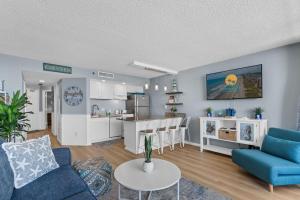 マートルビーチにあるOcean Forest Plaza Cozy Oceanfront Unit 1910のリビングルーム(青いソファ付)、キッチン