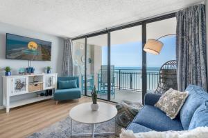マートルビーチにあるOcean Forest Plaza Cozy Oceanfront Unit 1910のリビングルーム(青いソファ、大きな窓付)