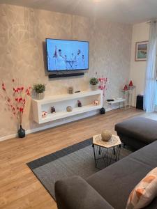 CourcouronnesにあるEden suiteの壁に薄型テレビが取り付けられたリビングルーム