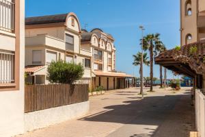 una strada in una città con palme ed edifici di Appartement rez-de-chaussée Plage du Grazel a Gruissan