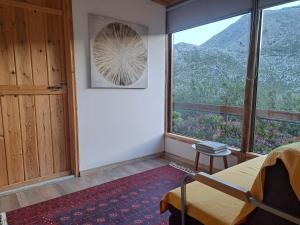 a bedroom with a bed and a large window at Wooden House at the Mountain-private in Paránimfoi