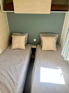 two beds sitting next to each other in a room at Mobil-Home Camping Parc Montana Gassin - Golfe de Saint-Tropez in Gassin +7 photos