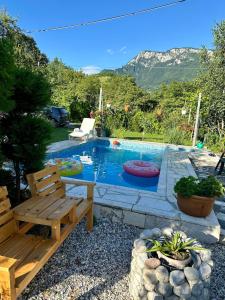 a swimming pool with a wooden bench and a bench at Guest House Queen in Konjic