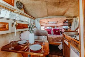 a caravan with a table and a kitchen and a bedroom at Yacht Hotel - Boat - pedal boat, motorboat FREE in Mielno