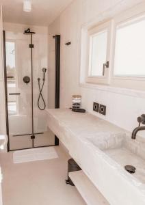 un bagno bianco con doccia e lavandino di Vila Amara - Resort Vita a Drage Altre 29 foto