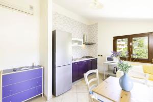 a kitchen and dining room with a refrigerator and a table at Giaco's Apartments 2 in Villasimius