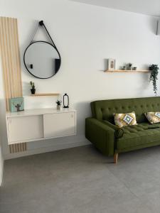 a living room with a green couch and a mirror at Apartaestudio Playa Paraíso in Aguadulce +10 photos