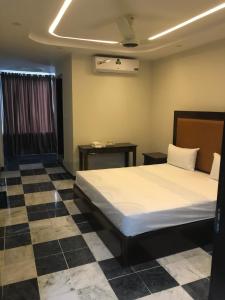 a bedroom with a bed and a checkered floor at Burn Hall view Hotel in Abbottabad