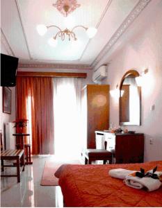 a bedroom with a bed and a table and a mirror at Hotel Avra in Karditsa
