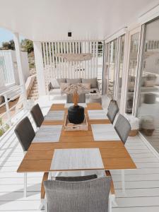 un tavolo e sedie in legno su un portico con divano di Vila Amara - Resort Vita a Drage