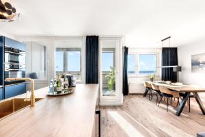 una cucina e una sala da pranzo con tavolo e sedie di Exklusives Apartment Sunrise mit Whirlpool, Pool und Sauna a Bremerhaven