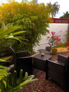 a patio with tables and chairs and plants at Studio Mohui RBNB in Punaauia