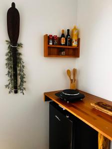a kitchen with a wooden counter with bottles on a wall at Studio Mohui RBNB in Punaauia +3 photos