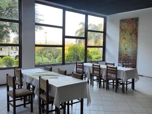 洛雷纳Valle Hotel的有桌椅和窗户的餐厅