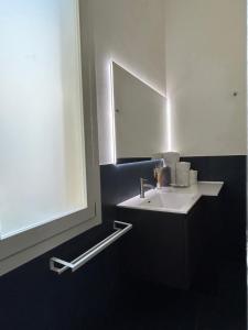 a bathroom with a white sink and a mirror at Domus in Modena