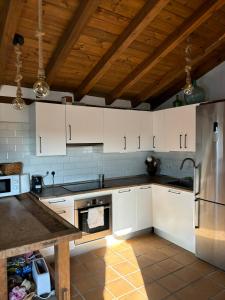 a kitchen with white cabinets and a stainless steel refrigerator at Casa Santierno in Valtablado del Río +16 photos