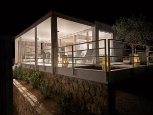 a glass house with a balcony on the side of it at Vila Amara - Resort Vita in Drage