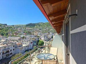 uma varanda com uma cadeira e vista para a cidade em Hotel The First em Gjirokastër