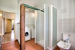 Un baño con inodoro y lavadora. en Cozy Counrtry House, en Terranuova Bracciolini