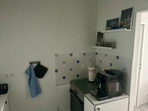 a small kitchen with a stove and a microwave at Ferienwohnung Moin in Bremerhaven +4 photos