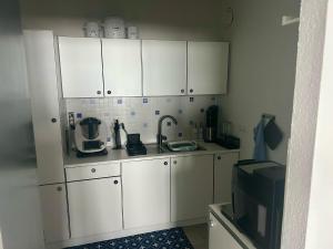 a kitchen with white cabinets and a microwave at Ferienwohnung Moin in Bremerhaven
