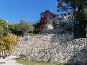 a stone retaining wall with stairs on top of it at Apartment ZenPunta in Pučišća