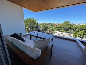 a couch on a balcony with a view of the city at Depto 2 Dorm en Posadas - Lomas de Alem in Posadas