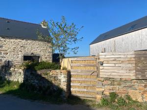 Le RozelにあるLa boulangerieの納屋の隣の石垣の隣にある木製の柵